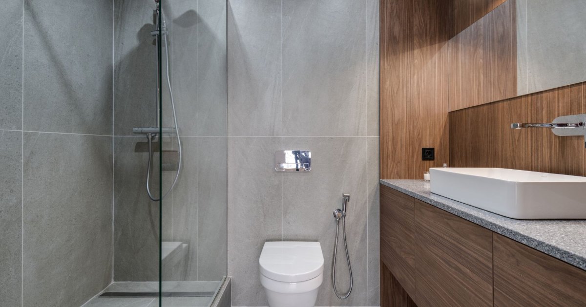 Bathroom with bath and glass shower A bathroom with a wood panelled bath alongside a glass walled shower