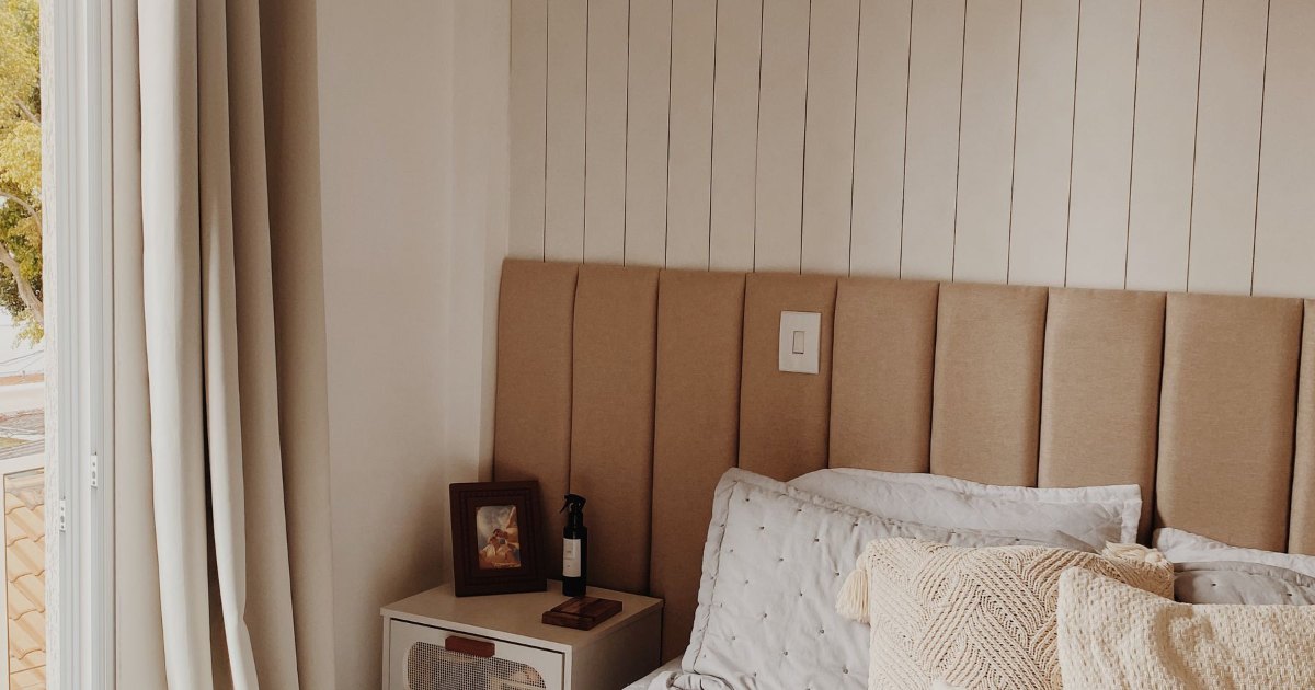 A neatly made bed with a wooden headboard