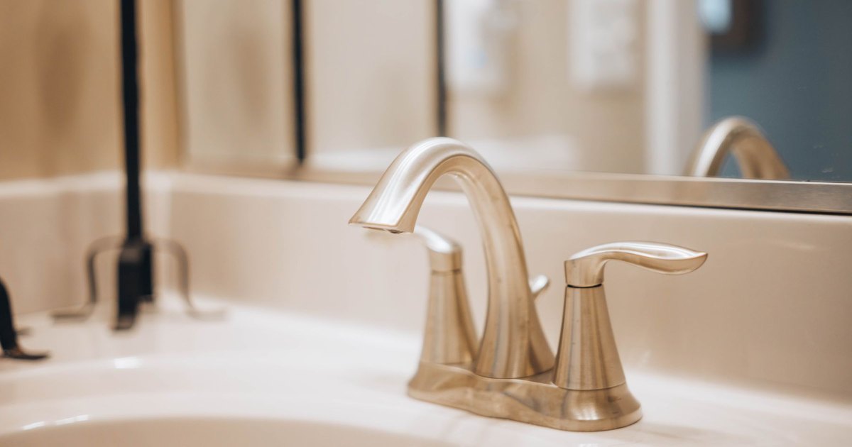 A close view of a brushed metal mixer tap on a bathroom basin