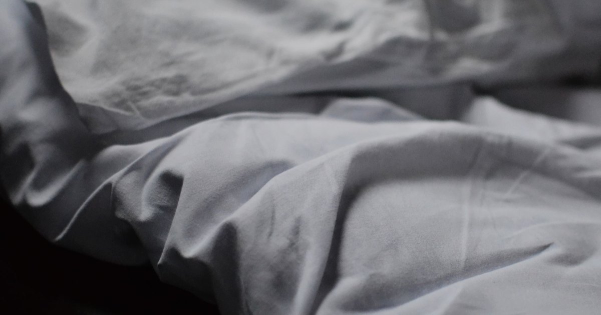 A close view of a grey duvet spread across a bed