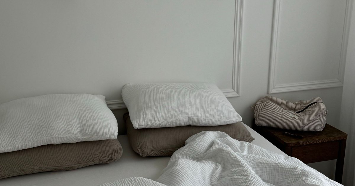 Made bed in a plain room A made bed with grey bedding in a simply furnished room