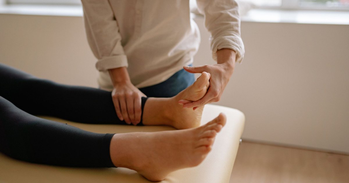 Treating an ankle A close view of hands supporting and treating an ankle