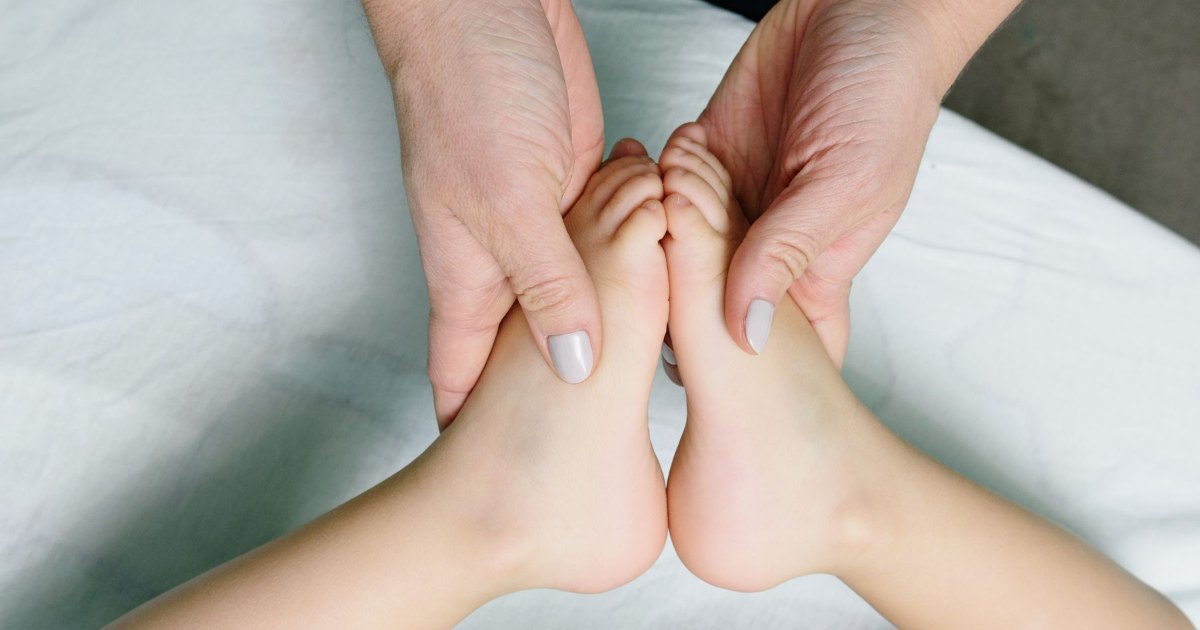 A close view of both feet being massaged