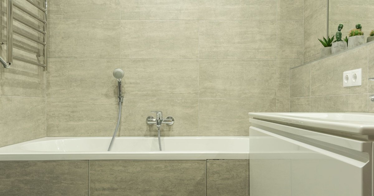A bath alongside wood panelling in a calm, modern bathroom