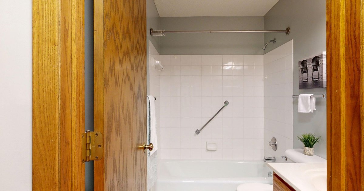 Accessible bathroom with grab rail An accessible bathroom with a horizontal grab rail beside the bath and a wide doorway