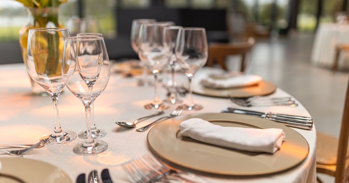 A dining table laid with glasses and cutlery