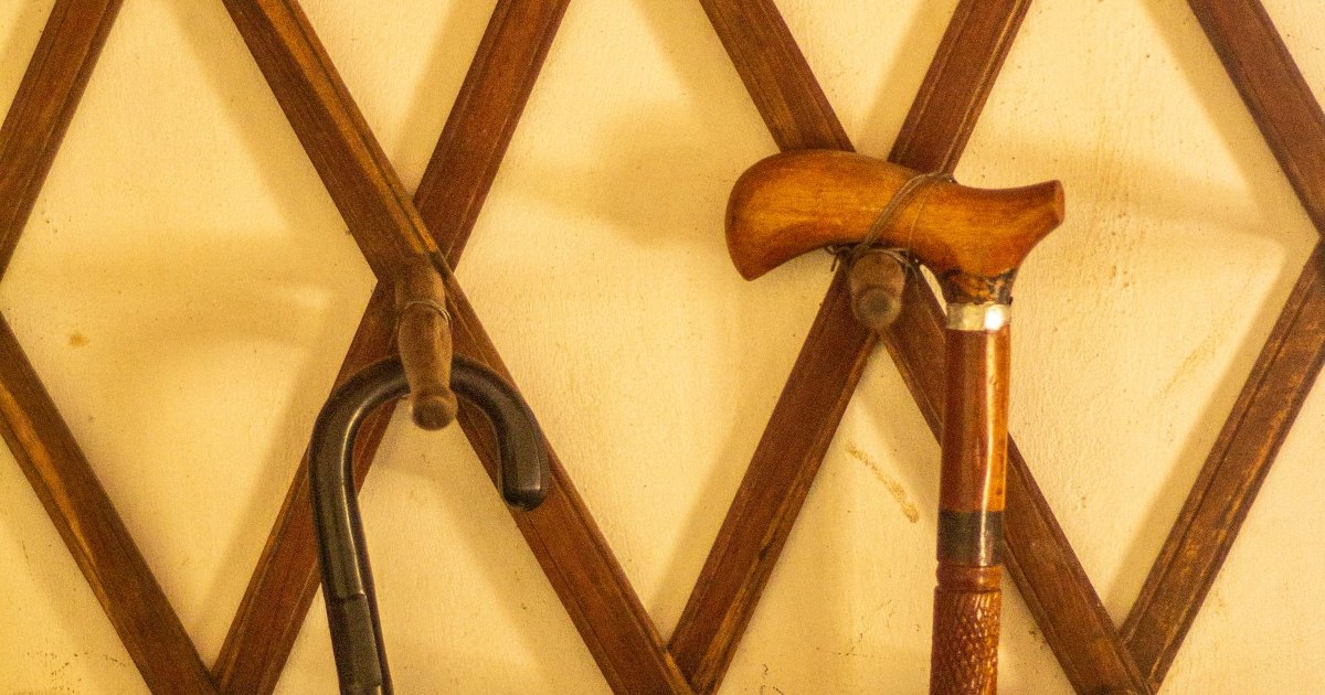Wooden walking sticks arranged against a bright yellow background