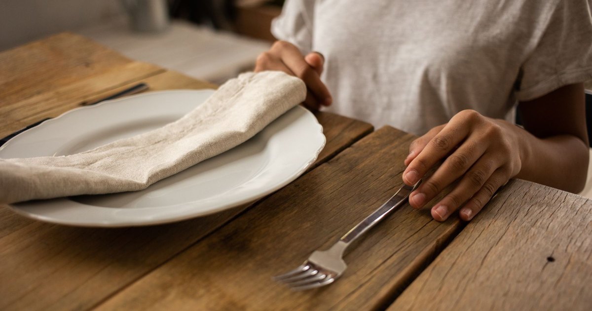 Napkin and cutlery A folded napkin and cutlery on a wooden table