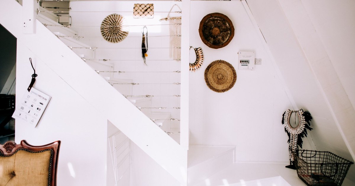 Staircase with decorated wall A white staircase with framed pictures and plates on the wall alongside