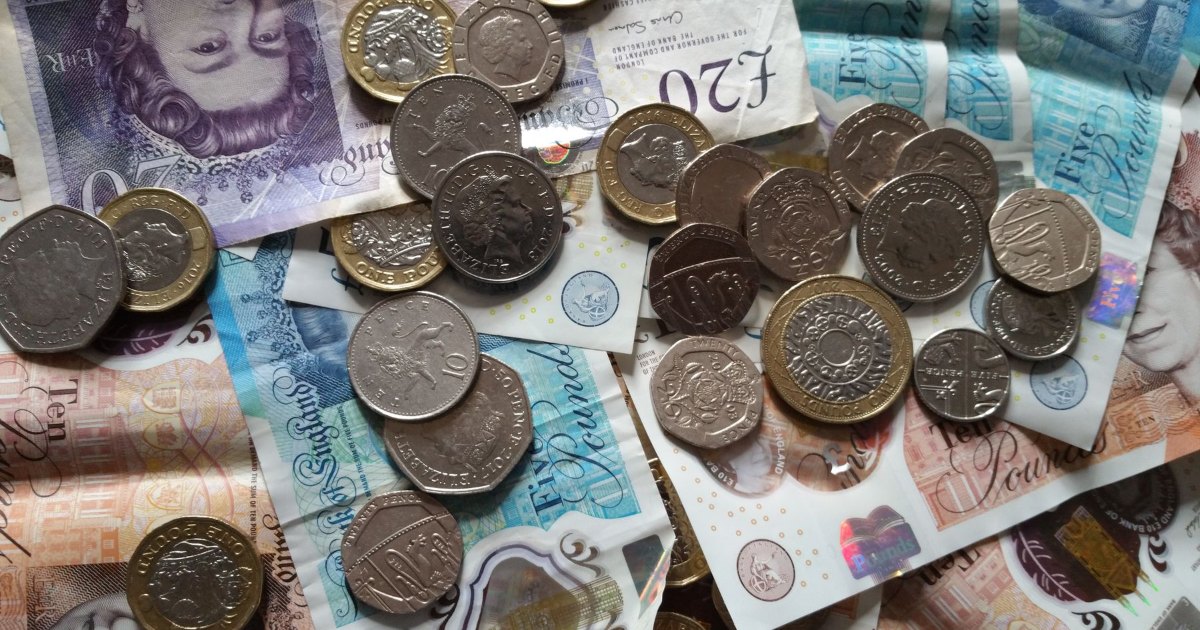 A pile of British pound coins and banknotes
