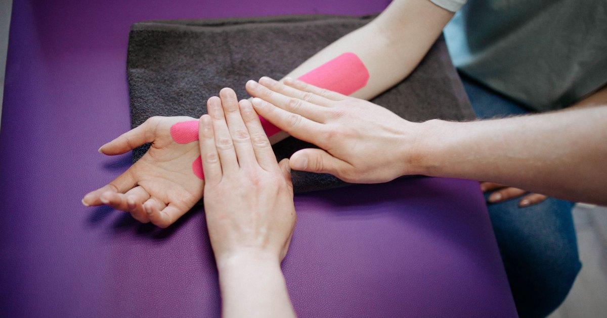 A close view of tape being applied across a hand