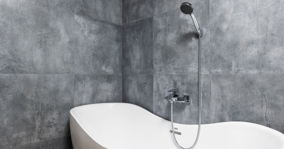 Freestanding bath with mixer tap A white freestanding bath with a wall mounted mixer tap and shower hose