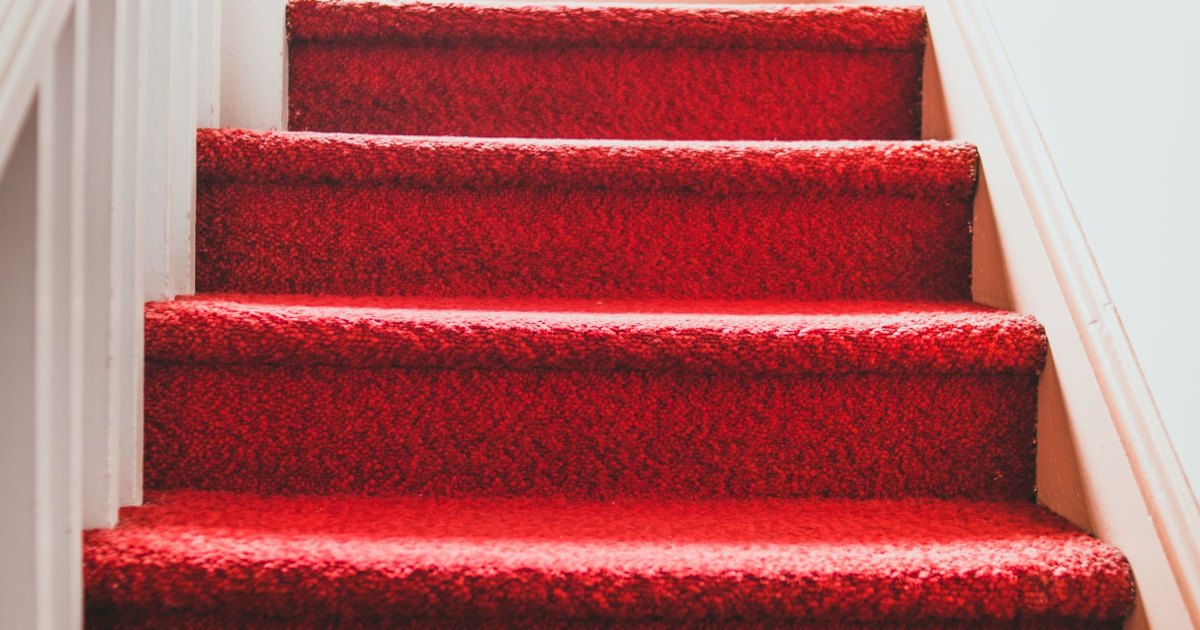 Red stair carpet detail A close view of red carpet on stair treads with a white balustrade