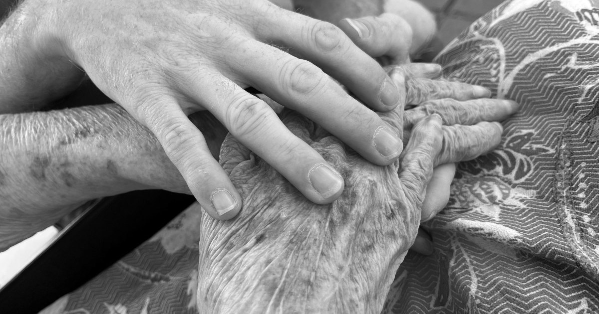 A black and white close view of a pair of older hands