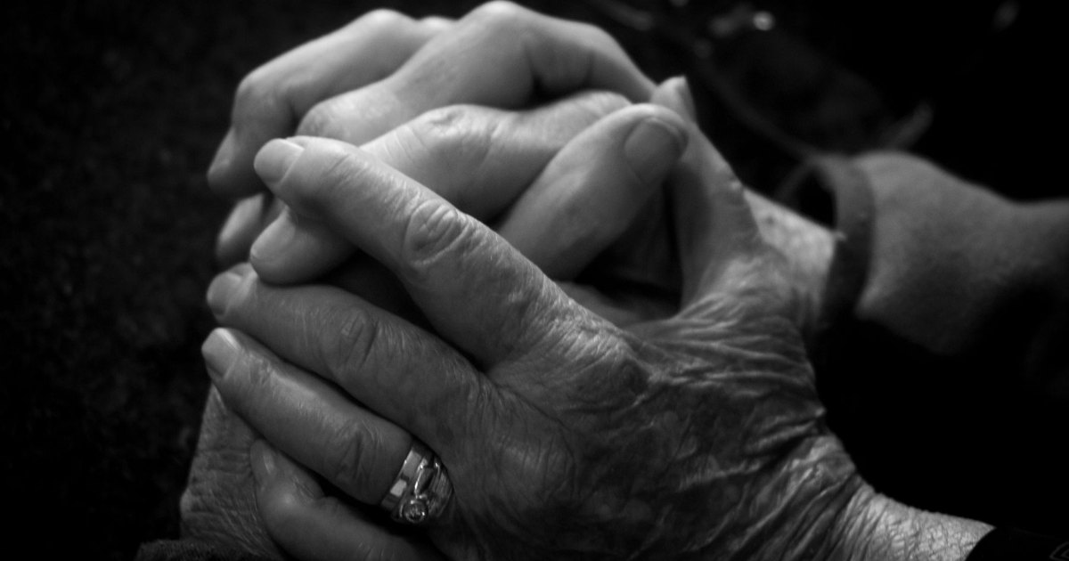 A black and white close view of two hands held together