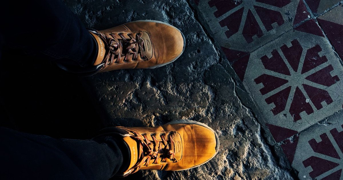 A close view of walking boots on a patterned path
