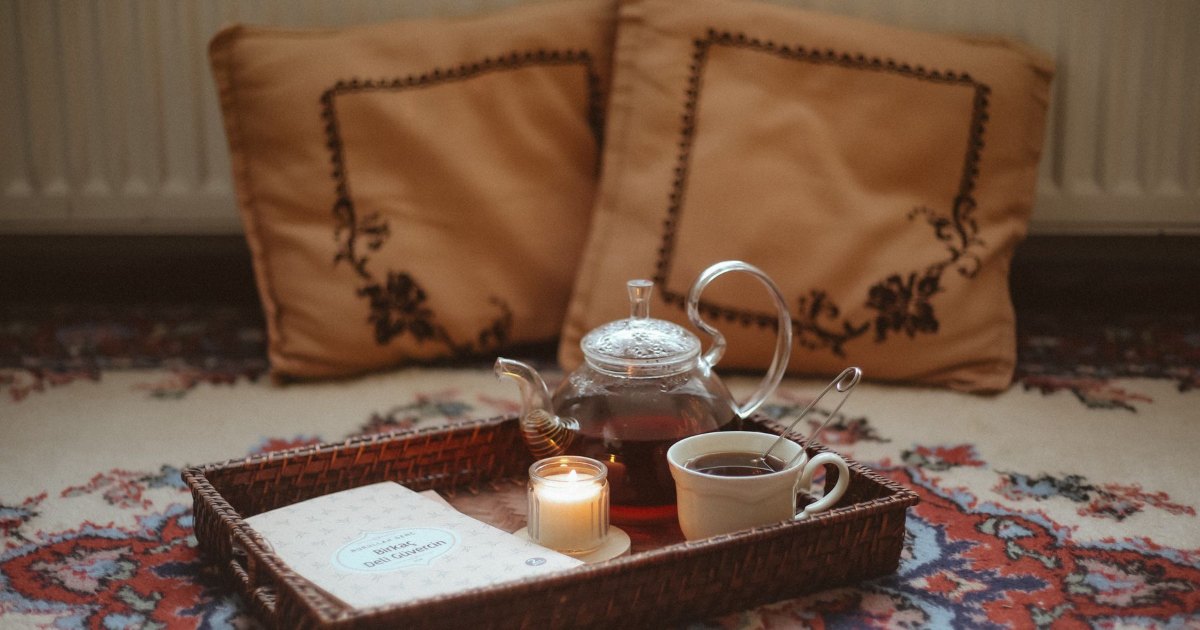 A tray with a teapot and cups set out at home