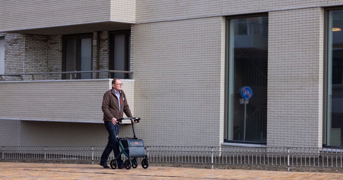 Walking with a rollator outdoors A person walking along a pavement with a rollator walker