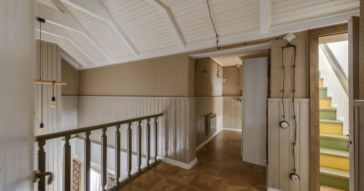 A narrow wooden staircase leading to the upper floor of a house