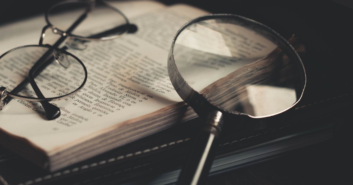 A pair of reading glasses resting on an open book