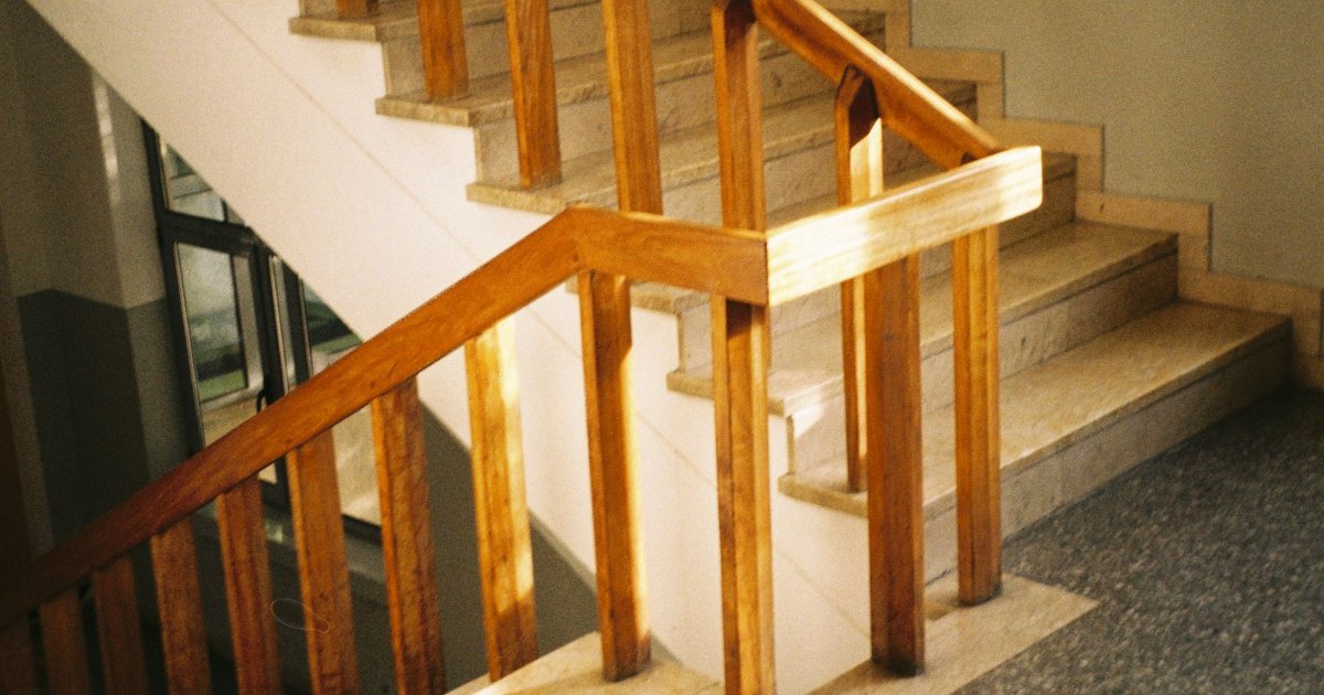 A wooden staircase with a polished handrail in a home hallway
