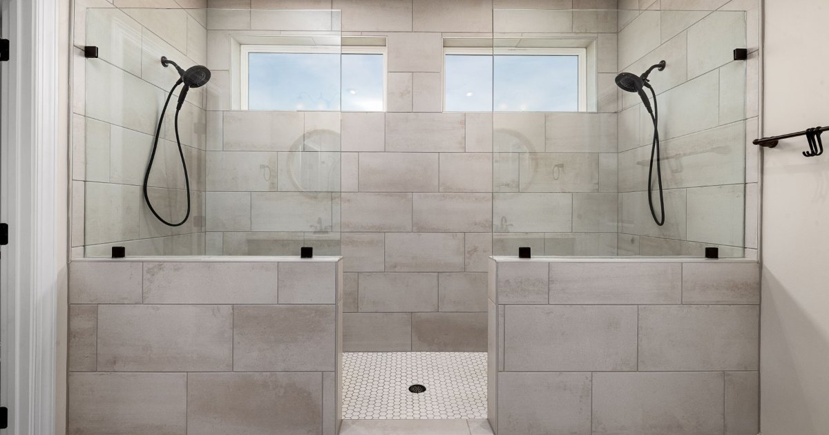 Twin walk-in shower in grey tile A large walk-in shower area tiled in grey with two shower heads
