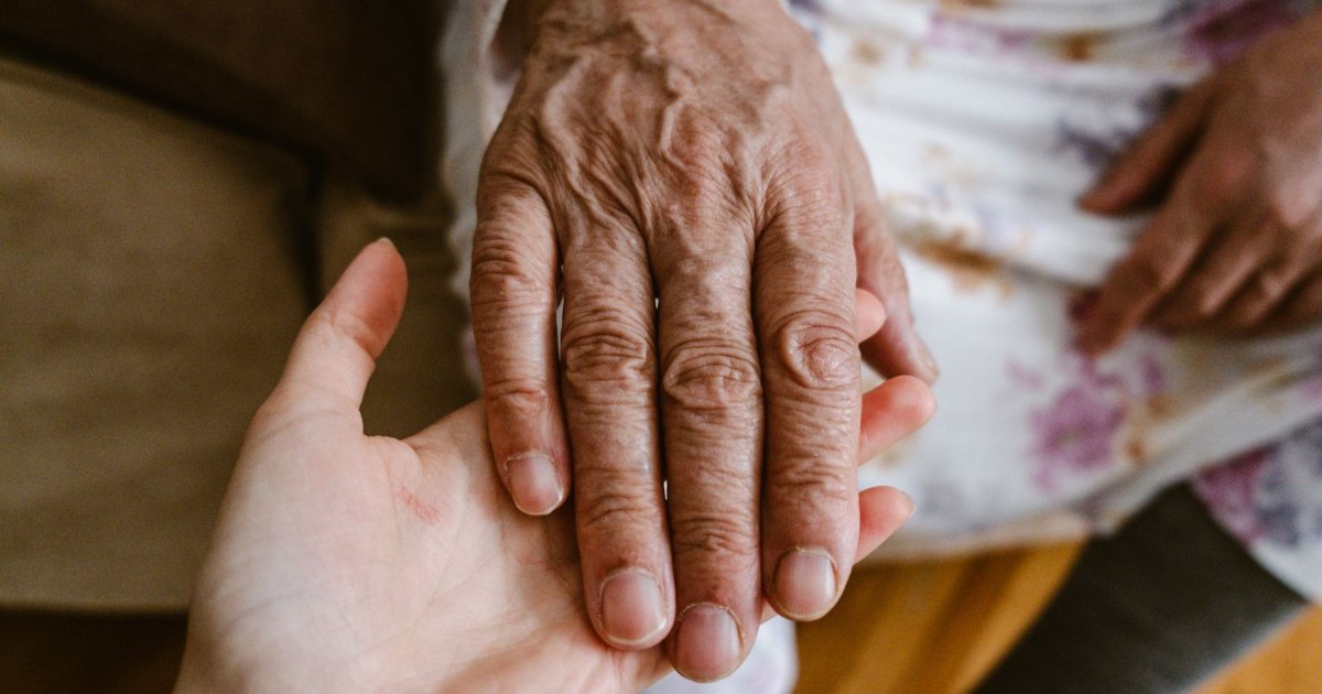 A close view of older hands holding a cup