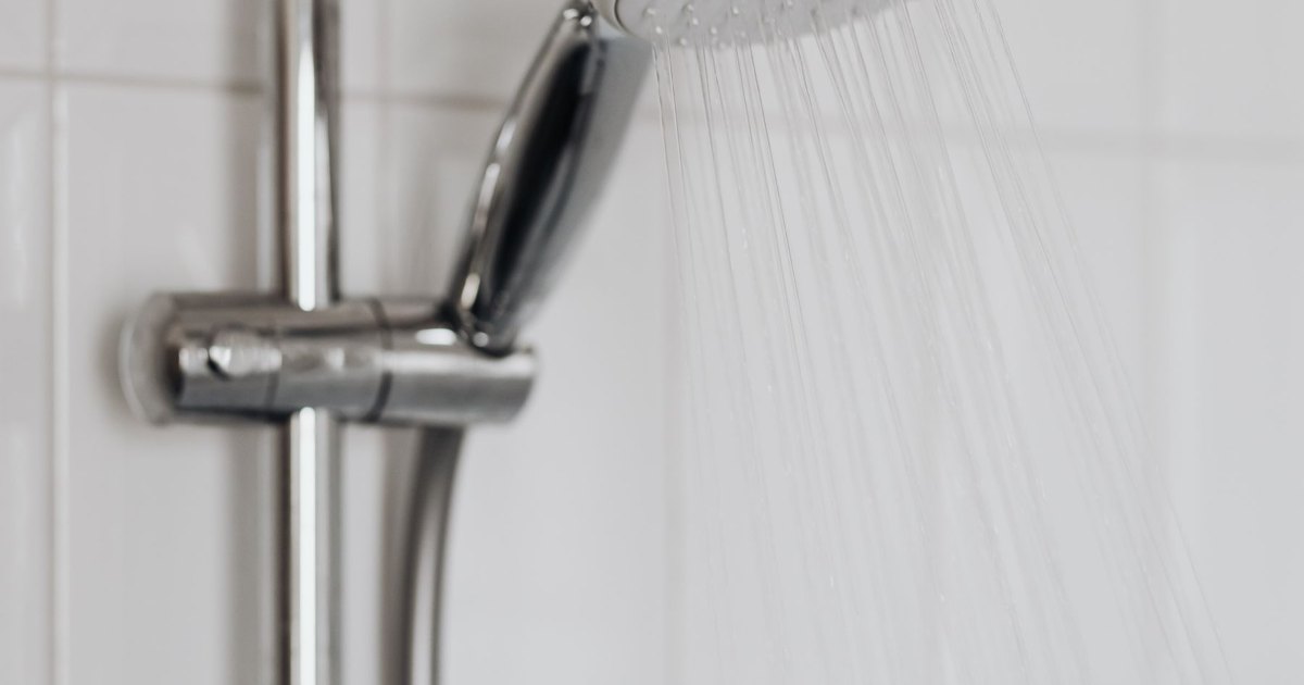 A close view of a chrome shower mixer valve mounted on the wall