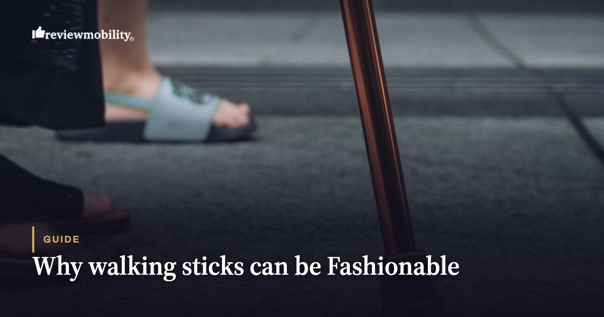 Close-up of feet in sandals on a sidewalk with a wooden walking cane in the foreground; introduces a guide on fashionable walking sticks.